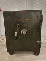 Front view of Mosler safe showing overall condition, combination dial, handle, hinges, wheels