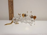 Group shot of two elephant and one kangaroo crystal figurines, ruler for scale