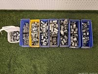 Overall view showing seven bins of assorted conduit fittings