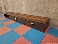 Front view of full shelving unit showing open cubby and two drawers