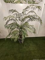 Full view of artificial palm in urn planter