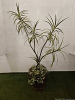 Full view of artificial plant in wooden planter