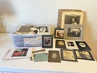 Overall lot view with plastic bin and spread out photographs, postcards and letters