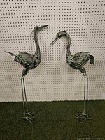Both metal bird sculptures standing side by side
