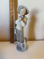 Front view showing full figurine with ruler for scale