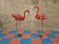 Both metal flamingo sculptures side by side