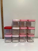 Front view of stacked square glass jars showing lid colours