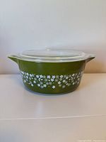 Side view of green Pyrex casserole with floral pattern and lid