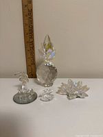 All four crystal figurines arranged with ruler in background for scale