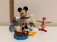 Group shot of all five figurines with ruler for scale