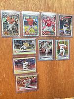 All nine sleeved and toploaded cards laid out front view