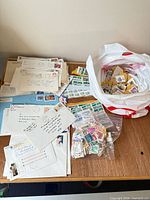 Overall view of mailed covers, bags of stamps on table