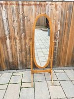 Front view of entire cheval mirror showing oval glass, frame, supports and base