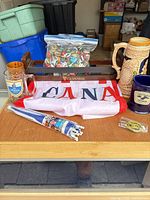 Full lot overview showing mugs, stein, carrier, flag, bottle caps, umbrella, pin