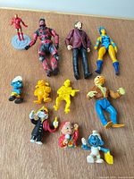 Overview of all 11 figures laid out on wood surface