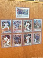 All nine sleeved and toploaded Topps Chrome refractor baseball cards displayed on wood background