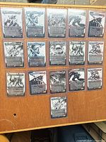 Overview of 18 of the borderless rare cards in toploaders laid out on a table