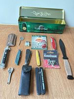 Overall view of all items including After Eight tin, knives, tools, packaged accessories
