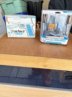 Both Nyko Perfect Shot and Charge Station packages on table