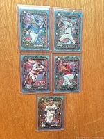 All five Topps Holiday 2024 Blue Parallel cards in toploaders