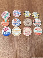 All 12 milk bottle caps arranged on tabletop