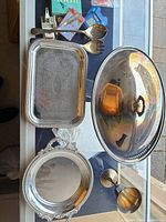 Overall view of all seven stainless steel pieces arranged on table