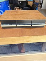 Closed wood-grain cassette storage box front view