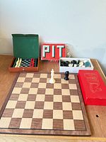 Group shot showing wooden chess board, plastic pieces box, travel set case, Pit game