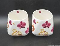 Both porcelain lantern teacups front view showing orchid and swirl decoration
