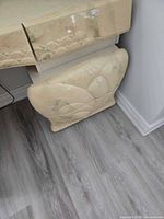 Lower left pedestal drawer showing carved motif and finish