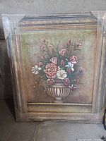 Full view of framed floral painting wrapped in plastic