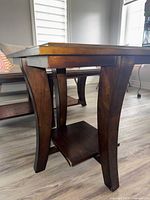 Overall view of side table showing curved legs and lower shelf