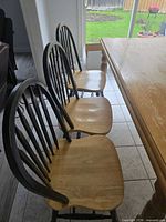 Three matching solid wood dining chairs beside dining table