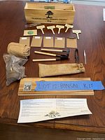 full kit laid out showing planter box, labels, tools, seed packets, burlap, soil disc, guide