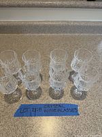 Eight crystal wine glasses arranged on countertop