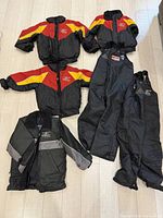 Four jackets and four pants laid out showing colors, sizes not visible