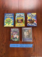 All five books laid out on wooden surface with handwritten lot number