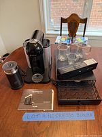 Coffee machine, frother, mugs, capsule drawer, manuals, capsule box overview