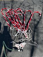 Bundle of nine red and white candy cane lights with wiring and plug visible