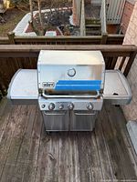Front view of Weber Genesis stainless steel natural-gas grill on deck