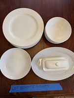 Stack of 8 dinner plates, 6 bowls, 2 side plates, platter and butter dish displayed on table