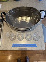 Overview showing stainless steel ice bucket and four wine glasses on countertop