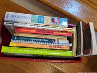 Cookbooks stacked inside red metal box