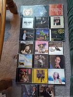 Overview of all 20 CDs laid out in five rows on carpet