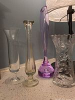 Four bud vases side by side on counter showing sizes and colors