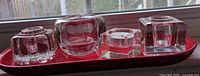 All four crystal holders lined on red tray