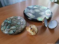 Overview of both resin coasters/trivets and two hinged shell boxes, one box open