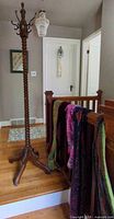 Full view of coat rack and scarves draped nearby