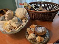 overview of glass bowl with shells, wicker basket with duck scoop, resin trivet set, wood box