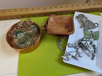 Group view showing copper pot, glass stoppers, wood dishes, metal hooks and pendant
